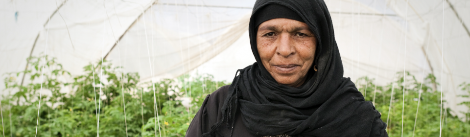 A woman gardening in a greenhouse